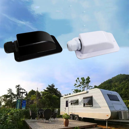 Two outdoor RV window vent or air intake components shown floating above a campsite scene with a travel trailer, trees, and sky. One component is black and one is white, suggesting a set or color variants.